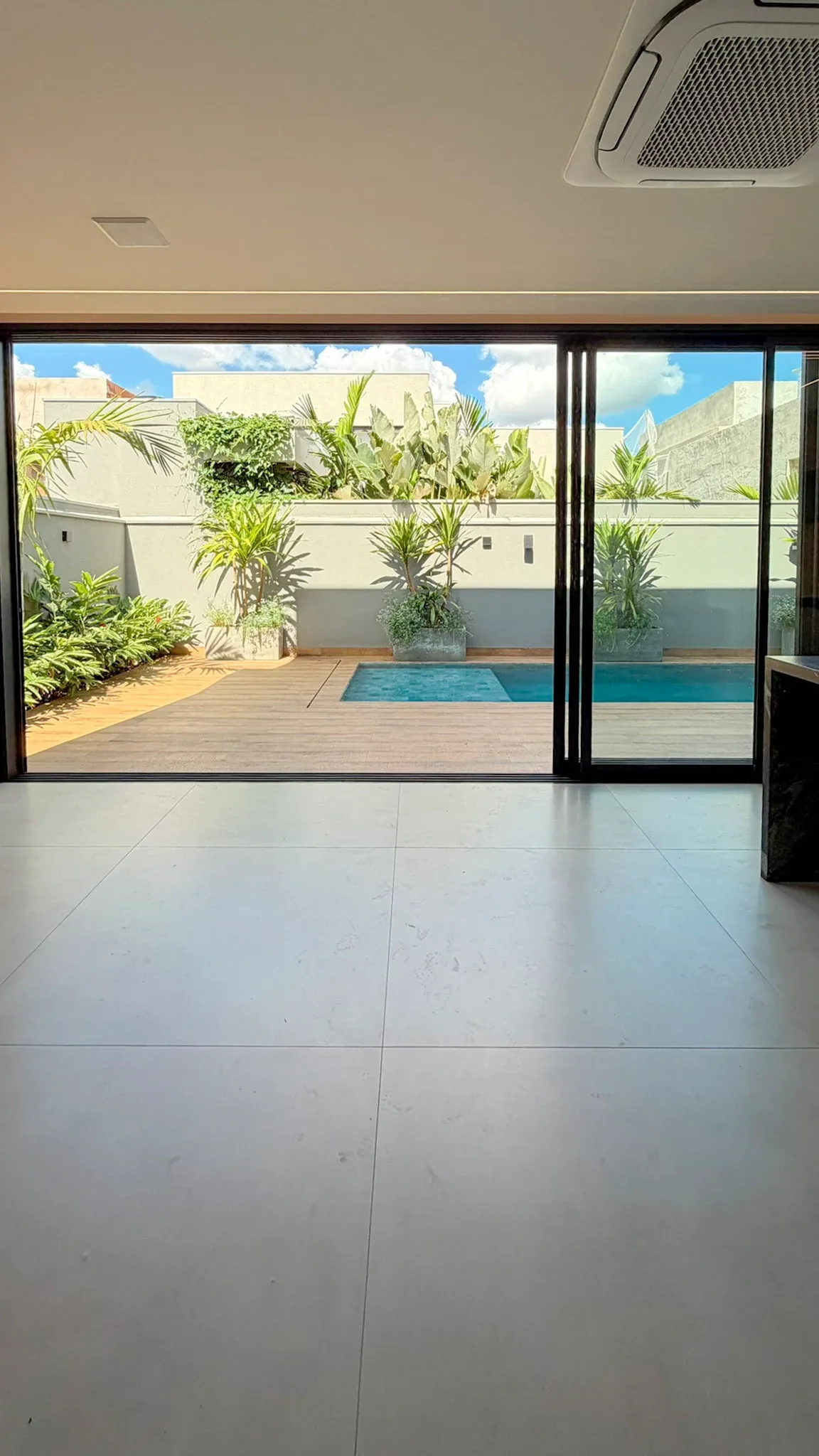 Portas de vidro conectam o interior ao deck e à piscina.