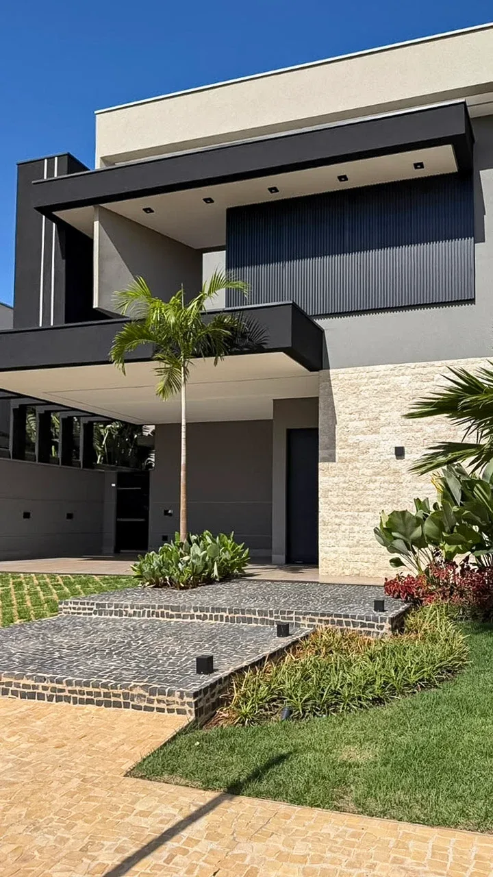 Fachada principal com acesso, garagem e paisagismo.